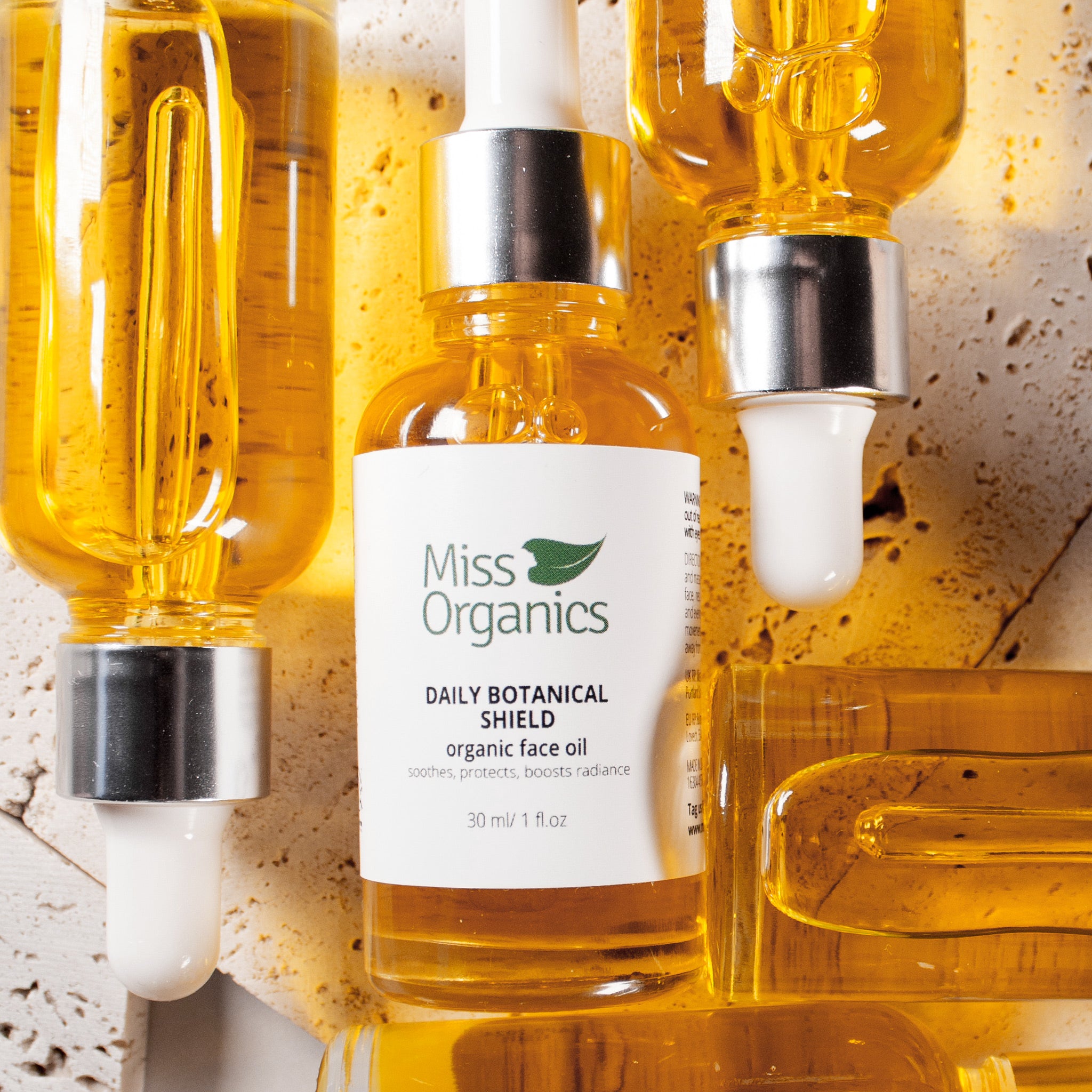 Daily Botanical Shield Organic Face Oil in glass bottle on stone background